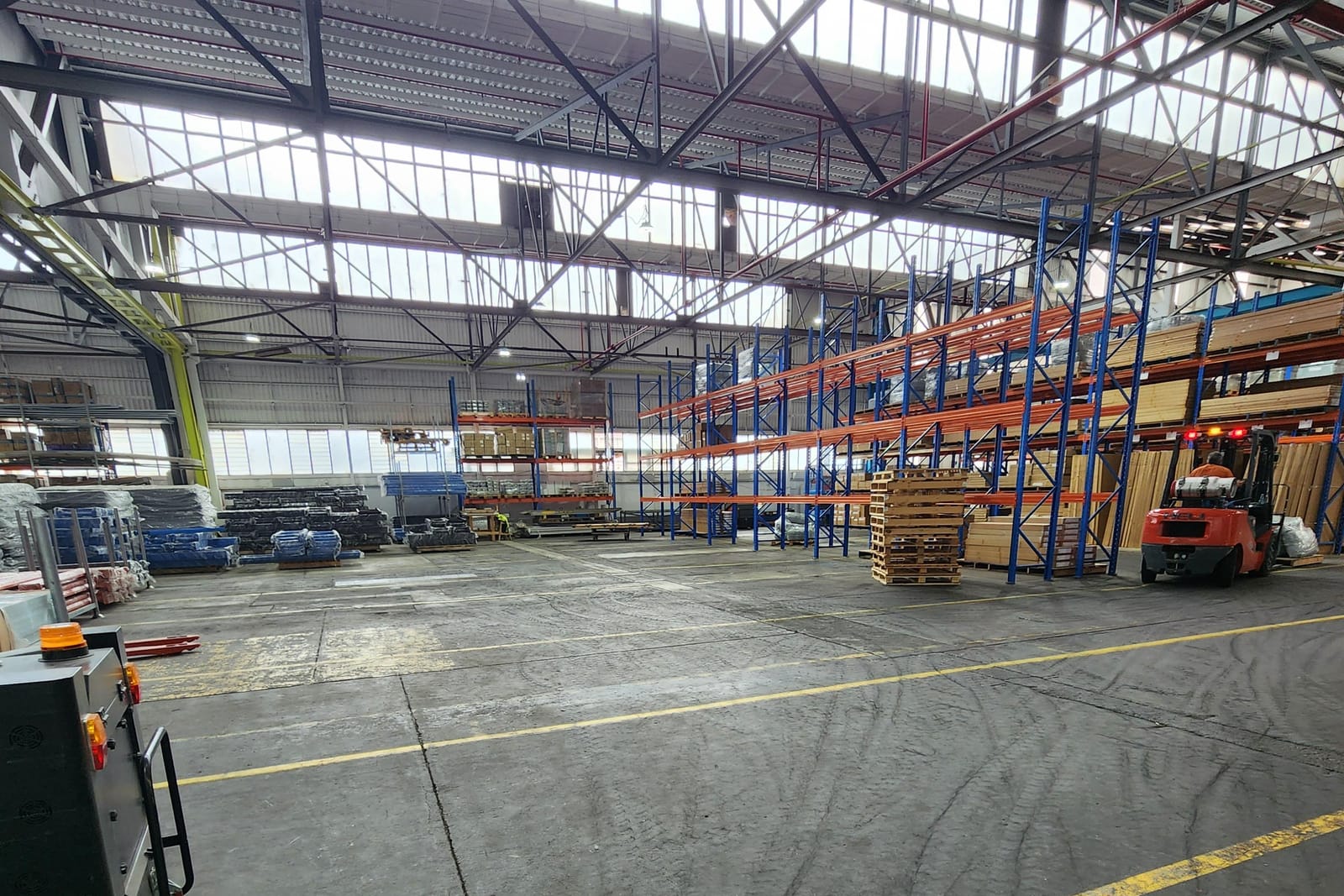 A client warehouse floor with racking, timber stock and a forklift at work